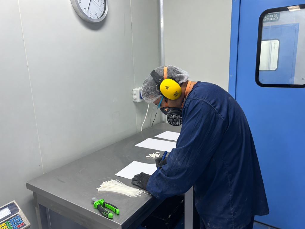 Operario revisando cápsulas en la sala de producción de Mondial Pack